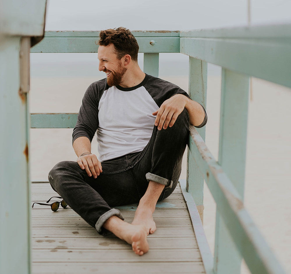 healthy man sitting on a lifeguard station at the beach