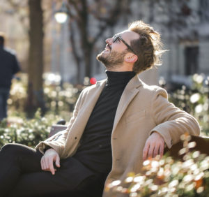 happy man sitting on a bench and looking up