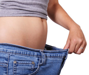woman pulling on the waist of her jeans to show weight loss