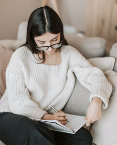 Woman writing in her gratitude journal