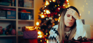 Woman with head in hand dealing with holiday stress